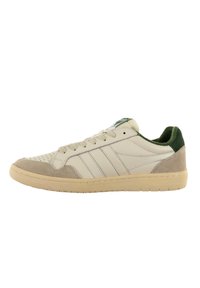 Zapatillas deportivas blancas con acentos verdes, parte superior de cuero, detalles de ante en el talón, caja de los dedos perforada y suela de goma.