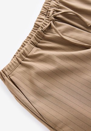 Bruine pinstripe broek met een elastische tailleband en trekkoord. Zachte stof met stiksels en voorzakken.
