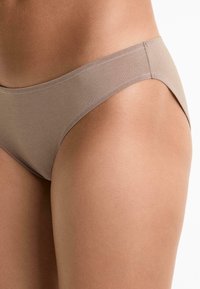 Hnedé spodné prádlo s hladkou textúrou a stredným strihom. Dizajn obsahuje čisté línie a minimálne švy pre súvislý vzhľad.