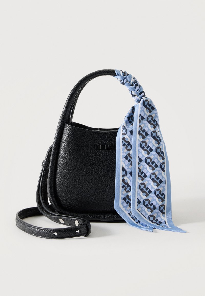 Sac à main en cuir noir texturé avec une petite poignée et une longue bandoulière, avec un foulard bleu à motifs noué à la poignée.