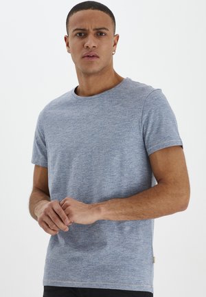 Tricou cu mânecă scurtă, de tip crew-neck, dintr-un material ușor albastru melanj. Prezintă o croială lejeră și detalii discrete de cusătură la tiv.