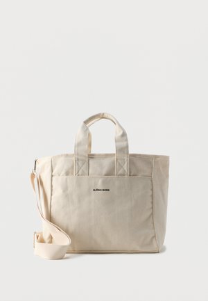 Sac fourre-tout en toile beige avec deux poignées, poche avant, bandoulière ajustable et logo "BJÖRN BORG" centré sur la poche.