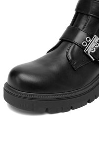 Czarne skórzane botki za kostkę z detalem klamry, teksturowana powierzchnia, zaokrąglony czubek oraz chropowata gumowa podeszwa z bieżnikiem.