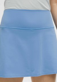 Plavi atletski šorts napravljen od glatkog, rastezljivog materijala. Ima široku elastičnu traku u struku i ravne šavove za udobnost.