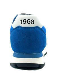 Sneaker in suede blu con tallone bianco che presenta il numero "1968". Suola nera notevole e parte superiore testurizzata per garantire aderenza. Design classico delle scarpe da corsa.