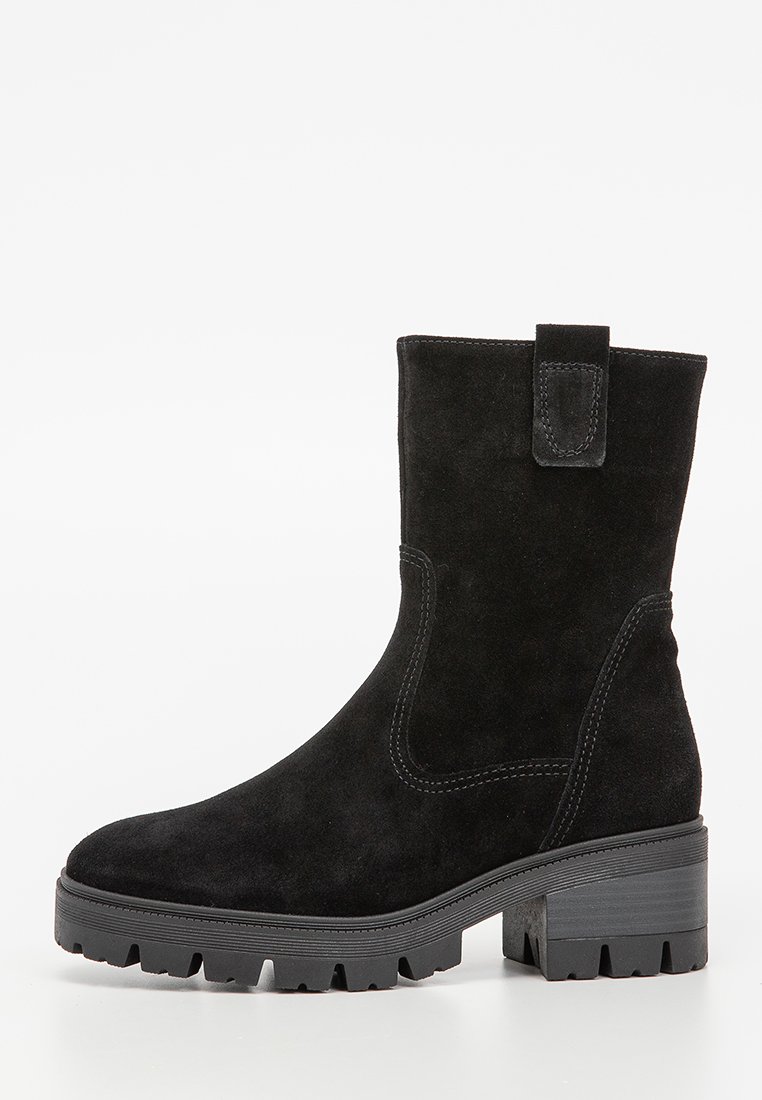Bottines noires en daim avec un talon bloc robuste, des panneaux élastiques sur les côtés et une languette à l'arrière. Présente une surface texturée et une semelle extérieure rugueuse.