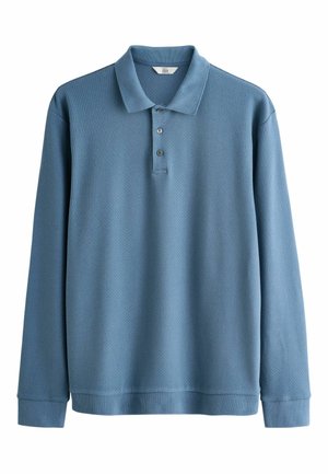 Polo a maniche lunghe di colore azzurro chiaro, realizzato in tessuto texturizzato, con colletto e patta con tre bottoni.