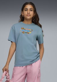 Lyseblå bomulds T-shirt med korte ærmer, der har et farverigt grafisk print af en leopard og teksten "PUMA" på forsiden.