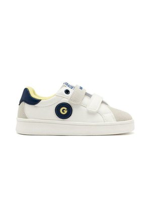 Baskets blanches avec des accents bleu marine et gris, bandes Velcro, un écusson rond et une protection de bout texturée. Design léger et décontracté.