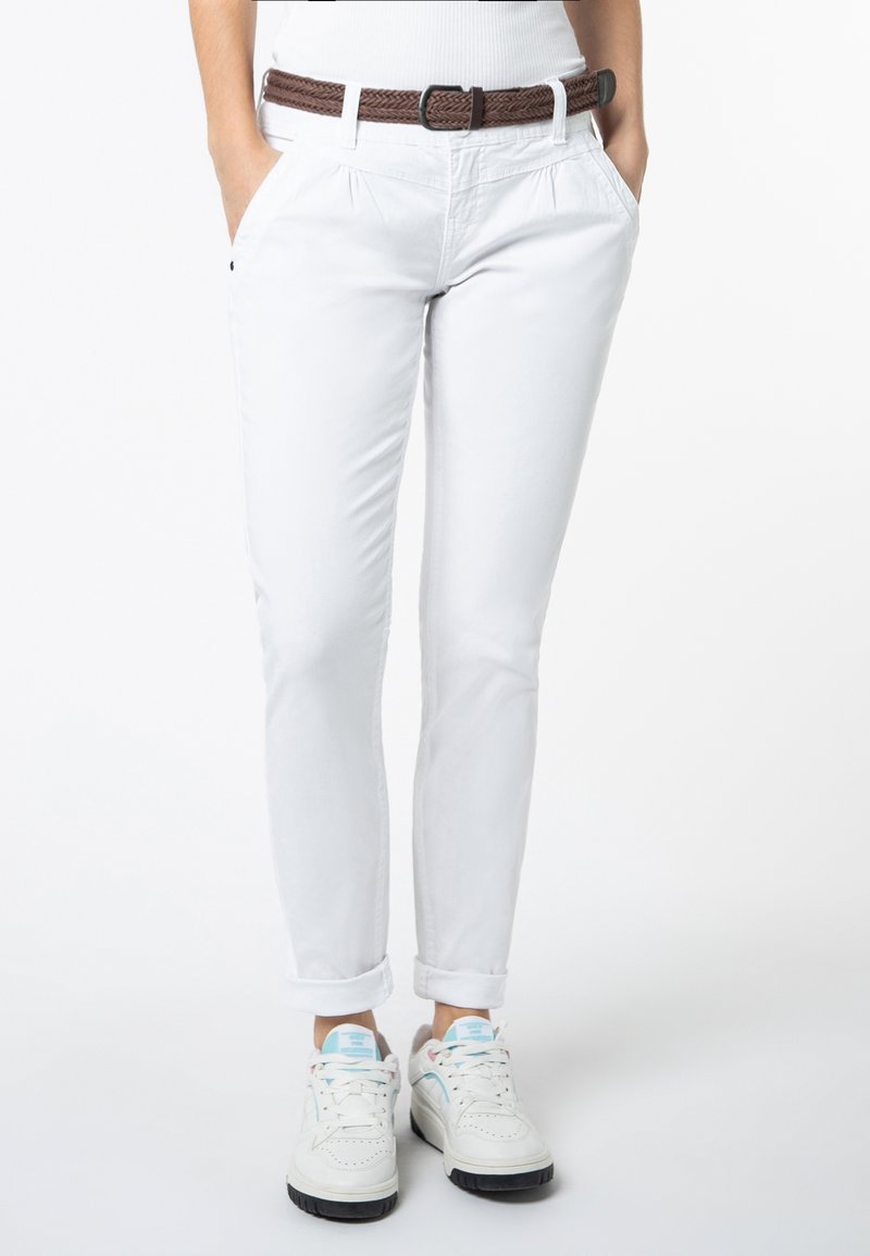 Witte katoenen broek met een bruine geweven riem. De broek heeft een slimfit ontwerp, opgerolde manchetten en zijzakken. Gemaakt met witte sneakers.