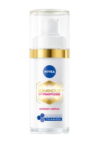 White pump bottle with a transparent cap, gold accents, and blue logo. Label features "LUMINOUS 630® ANTI-PIGMENTFLECKEN" in pink and hexagonal designs.
