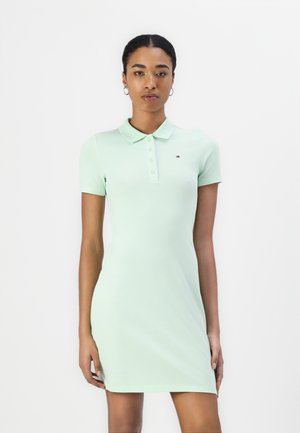 Rochie polo verde mentă cu o siluetă ajustată, mâneci scurte, o închidere cu nasturi și un mic logo accent pe piept. Material moale și neted.
