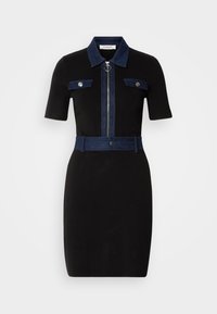 Robe noire à manches courtes, accents en denim sur le col, les poches et la ceinture. Présente une fermeture éclair centrale et une silhouette ajustée.