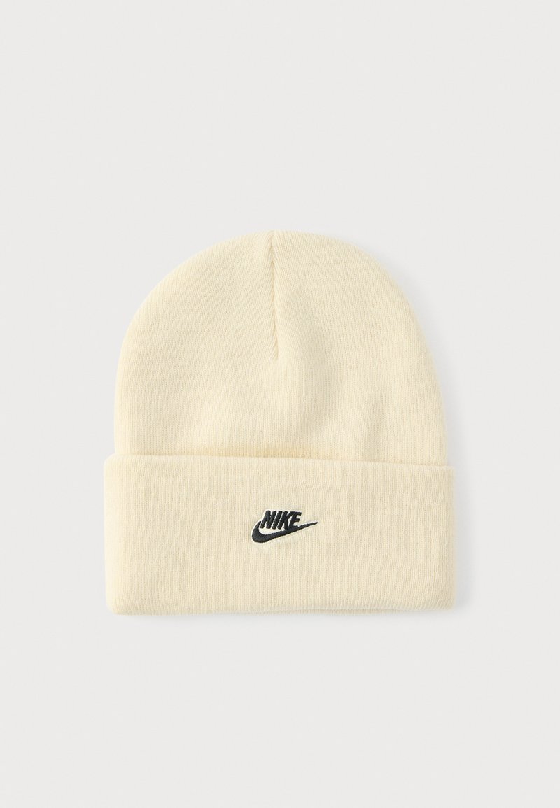 Kremowa dzianinowa czapka z podwiniętym mankietem, z czarnym logo Nike z przodu. Miękka faktura i prosty, zaokrąglony kształt góry.