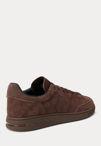Brązowy zamszowy sneaker z wiązaniem na sznurówki, gumową podeszwą oraz oznaczeniem Ralph Lauren na pięcie i bocznej podeszwie.