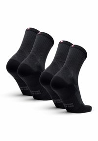 Calcetines negros de tobillo con patrones texturizados, refuerzo en el talón y una etiqueta de logo contrastante en el puño. Conjunto de tres pares. Tela suave.