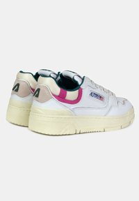 Sneakers bianchi con suola testurizzata, dotati di accenti rosa e teal, un design cucito e una patch con logo sul lato. Dettaglio testurizzato sul tallone.