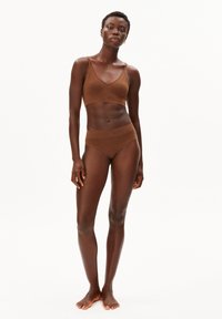 Bruine geribbelde bralette met dunne bandjes, gecombineerd met bijpassende hoogwaterbroekjes. Gemaakt van zacht materiaal met een naadloos ontwerp.