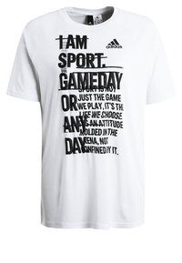 Bílé bavlněné tričko s výrazným černým nápisem. Design obsahuje sportovní fráze v různých velikostech a stylech písma. Logo Adidas na rameni.