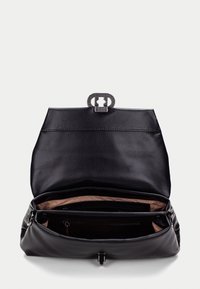 Černá kožená kabelka se strukturovaným designem, kovovým zapínáním a měkkým interiérem. Interiér obsahuje kapsy pro organizaci.