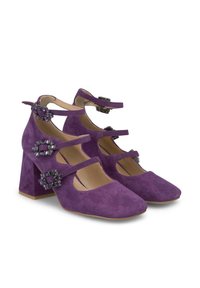 Le scarpe con tacco in suede viola presentano tre cinturini con fibbie decorative. I tacchi a blocco offrono stabilità e il design include dettagli intagliati.