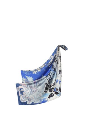 Foulard en soie à motif floral bleu et blanc, noué lâchement à un coin sur fond blanc.