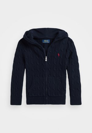 Navy blue knitted hoodie with a zip closure, featuring a cable knit pattern, two front pockets, and a small red logo on the chest.