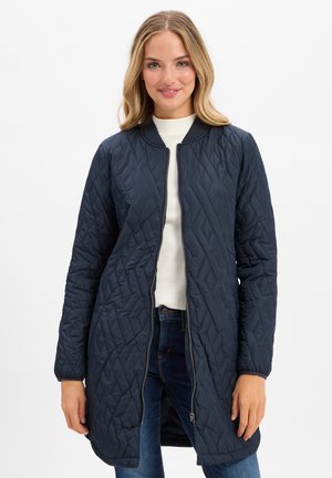 Marineblau gesteppter langer Mantel mit Reißverschluss, Rundhalsausschnitt und gerippten Bündchen. Verfügt über ein Rautenmuster und Seitentaschen.