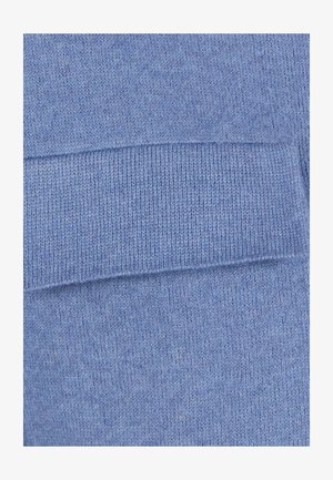 Close-up van lichtblauw gebreid stof met gedetailleerde geribbelde en gestructureerde steekpatronen.