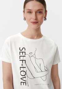 Weißes Baumwoll-T-Shirt mit einer minimalistischen Schwarzlinienzeichnung einer Figur und dem Text "SELBSTLIEBE". Es hat einen runden Ausschnitt und kurze Ärmel.