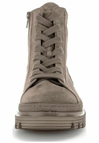 Bottes de cheville en daim beige avec une semelle en caoutchouc plate et texturée, dotées de lacets à l'avant et d'une fermeture éclair sur le côté pour un enfilage facile.