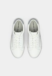 Witte leren sneakers met een gladde textuur, ronde neus en platte veters. Bevat een subtiele grijze accent op de hak en gedrukte branding aan de binnenkant.
