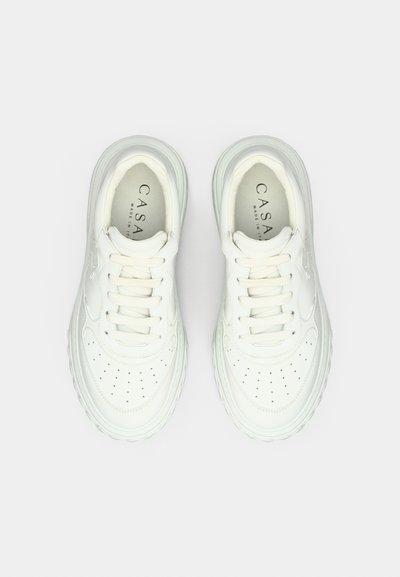 Λευκά δερμάτινα αθλητικά παπούτσια με διάτρητο κουτί δακτύλων, στρογγυλά κορδόνια και μαλακό πάτο. Διακριτικό λογότυπο στη γλώσσα, καθαρός μινιμαλιστικός σχεδιασμός.