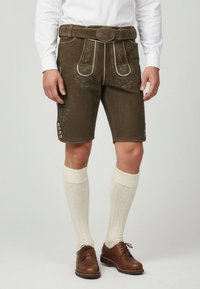 Brown leather shorts with embroidered floral patterns, fitted design, and side buttons. Paired with knee-length cream socks and brown shoes.