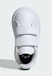 Zapatilla blanca con parte superior sintética lisa, que cuenta con dos correas de gancho y bucle, puntera redondeada y suela texturizada. Plantilla negra con impresión blanca.