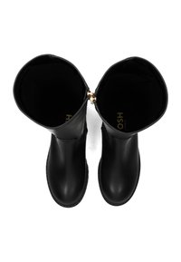 Un par de botas de cuero negro hasta la mitad de la pantorrilla vistas desde arriba, con tiradores de cremallera dorados visibles y puntas redondeadas.