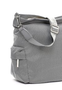 Borsa in tessuto intrecciato bianco e nero con chiusura a zip, tracolla regolabile grigia e tasca laterale con un accento argentato.