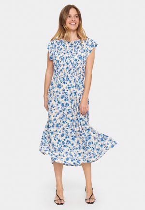 Floral midi dress featuring blue and beige flowers on a light background, with cap sleeves, cinched waist, and flowing skirt. Smooth fabric.