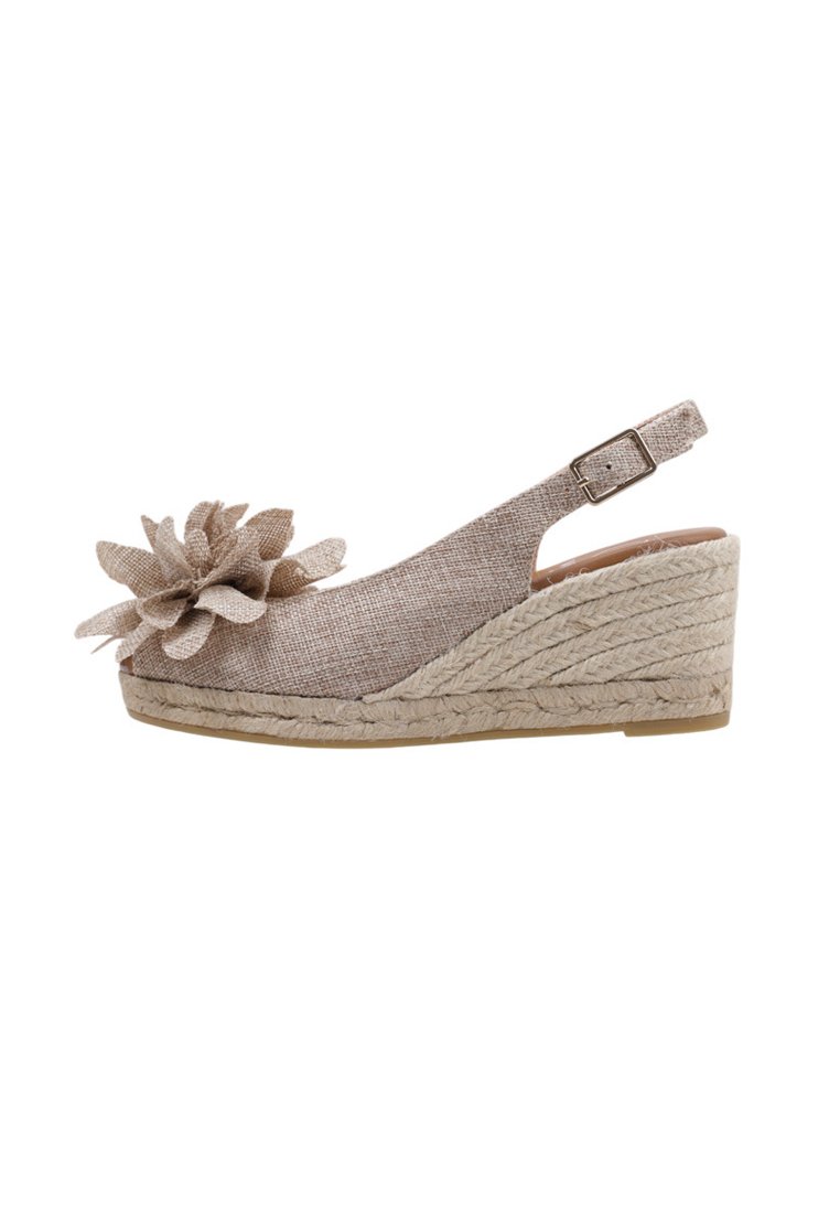 Sandale compensée en toile beige avec une tige en textile, semelle en jute tissé, accent floral et bride de cheville réglable.
