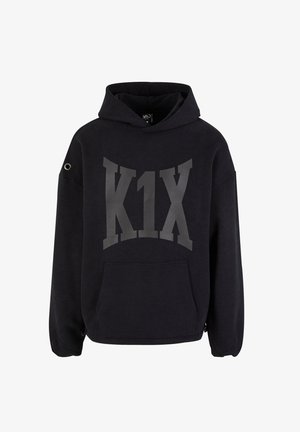 Fekete kapucnis pulóver nagy szürke "K1X" logóval, elülső zsebbel, oversize fazonnal és fémgyűrűs részlettel a bal ujján.