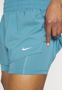 Shorts sportivi Nike in teal, con vita elasticizzata, logo bianco a contrasto e tessuto morbido e leggero dal design elegante.