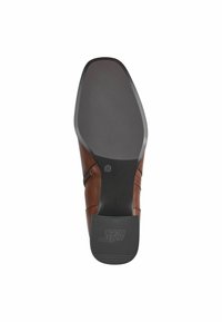 Chaussure en cuir marron avec une surface lisse, un bout légèrement arrondi et une semelle en caoutchouc noire texturée. Présente des accents de couture subtils.