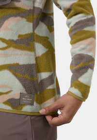 Fleece pullover met een camouflagepatroon in groen, grijs en pastelkleuren. Voorzien van een ritssluiting en een logo patch nabij de zoom. Zachte textuur.