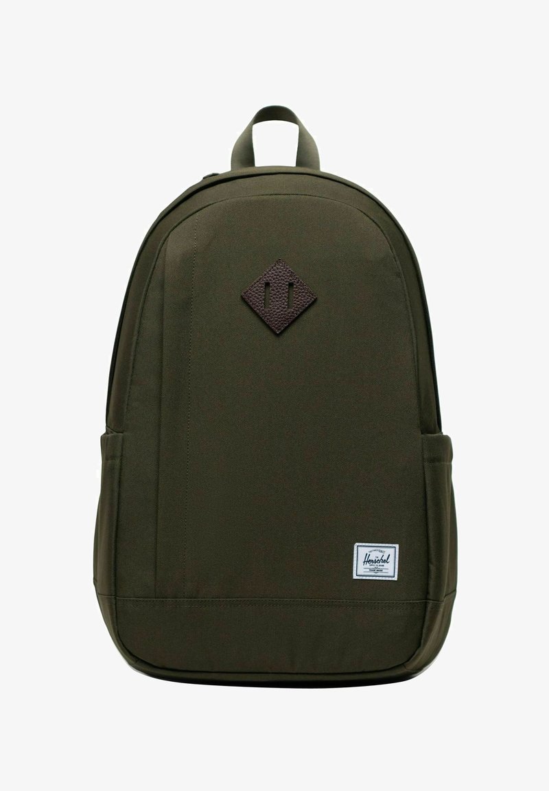 Zaino verde scuro con maniglia superiore, tasche laterali, toppa di pelle a forma di diamante e etichetta rettangolare bianca del marchio Herschel sul davanti.