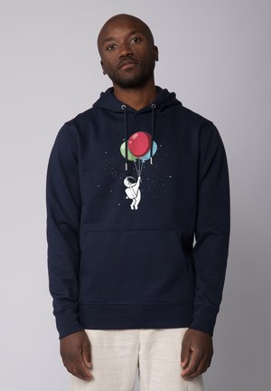 Marineblauwe hoodie met een frontale buidelzak, met een grafische afbeelding van een astronaut die kleurrijke ballonnen vasthoudt tegen een sterrenachtergrond.