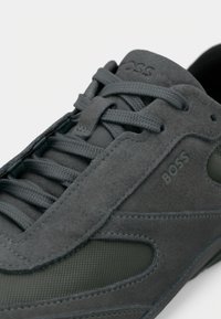 Baskets en daim et mesh gris foncé avec lacets assortis, marquage embossé « BOSS » sur le côté et la languette.