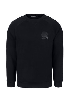 Musta pehmeästä kankaasta valmistettu collegetakki, jossa on raglansovitukset ja sävy sävyyn -logopainatus vasemmassa rintataskussa aurinkolaseista.