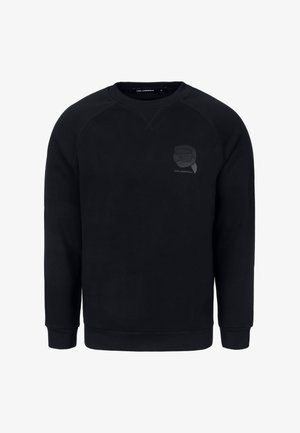 Musta pehmeästä kankaasta valmistettu collegetakki, jossa on raglansovitukset ja sävy sävyyn -logopainatus vasemmassa rintataskussa aurinkolaseista.