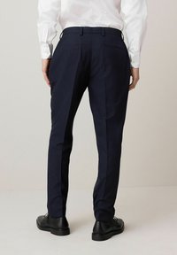 Marineblau gestreifte Hose aus Stoff; taillierte Passform mit glatter Textur; verfügt über zwei Gesäßtaschen und einen Bund mit Gürtelschlaufen.