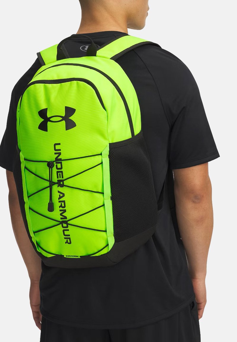 Zaino Under Armour verde brillante con dettagli neri, dotato di una tasca in rete e di un cordino elastico per un'adeguata sicurezza nella conservazione.